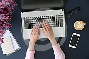 Top view of frmale hands on laptop keyboard photo