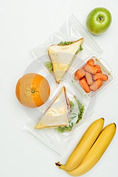 top view of fruits and sandwiches in ziplock bags