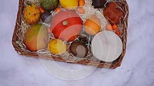 Top view fruits and vegetables in wicker basket on white snow outdoors. Healthful vitamin food on winter day in park