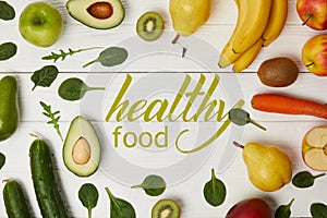top view of fruits and vegetables on wooden background with copy space, healthy food inscription