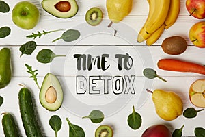 top view of fruits and vegetables on wooden background with copy space, time to detox inscription