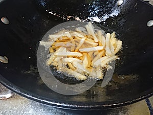Top view, frying french fries using black pan