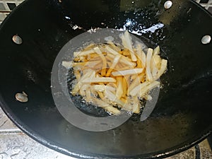 Top view, frying french fries using black pan