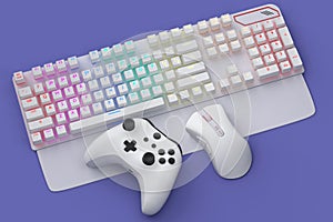 Top view gamer gears like joystick, keyboard, headphones and mouse on violet