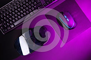 Top view a gaming gear, mouse, keyboard, joystick, headset, VR Headset on black table background.