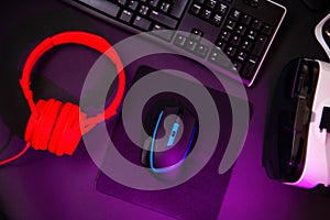 Top view a gaming gear, mouse, keyboard, joystick, headset, VR Headset on black table background.