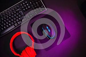 Top view a gaming gear, mouse, keyboard, joystick, headset, VR Headset on black table background.