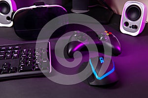 Top view a gaming gear, mouse, keyboard, joystick, headset, VR Headset on black table background.