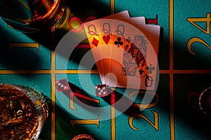 Top view of gaming table in a casino with glasses of whiskey and set of three ladies. Close up of a dark gambling poker