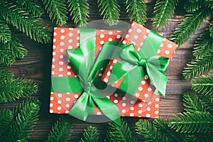 Top view of gifts box decorated with a frame made of fir tree on wooden background. New Year present time concept