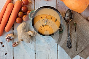 Top view of ginger carrot cream soup on white surface.