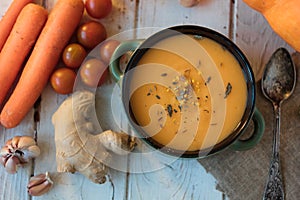 Top view of ginger carrot cream soup on white surface.