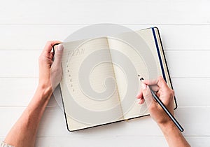 Top view of girl creating a plan in notebook