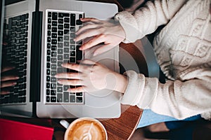 Top view girl hands typing on notebook