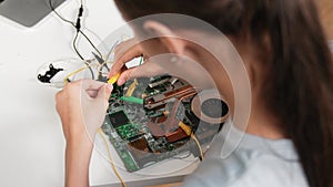 Top view of girl learning mother board with electronic equipment. Edification