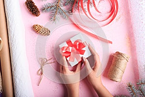 Top view of a girl making a Christmas present on a table background. Handmade present. Creative hobby concept.
