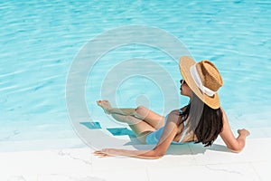 Top view of girl relaxing in swimming pool at luxury hotel. Summer holidays, vacation, travel concept. Copy space