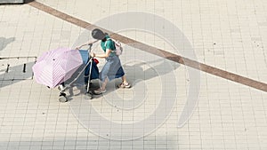 Top view of girl use wheel baby chair walk in pedestrian street