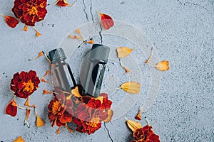 Top view of glass bottles of marigold essential oil with fresh marigold.