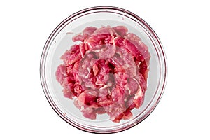 Top view of glass bowl with chopped pork tenderloin isolated on white background