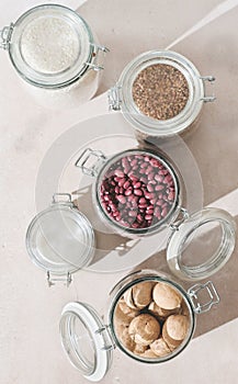 top view of glass jars with beans, rice and nuts with natural light. eco sustainable storage of raw food. kitchen