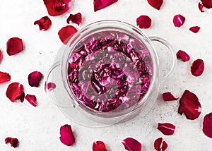 Top view of a glass pot with pink organic rose petals for making sweet syrup, alcoholic beverage, liquor or flower flavor wine.