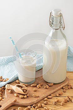 Top view of glass with straw and bottle with horchata on table with tiger nuts