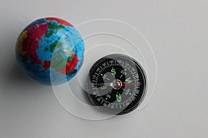 Top View Of Globe Model And Compass On White Surface