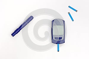 Top view of glucometer, lancet and test strips