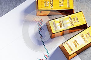 Top view of gold bars and chart growth price of gold