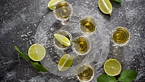 Top view of Golden Tequila shots served with lime and sea salt on table