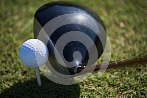 Top view of golf club and ball in grass