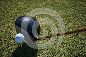 Top view of golf club and ball in grass