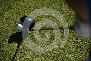 Top view of golf club and ball in grass