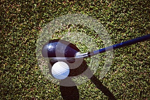 Top view of golf club and ball in grass