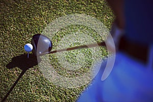 Top view of golf club and ball in grass