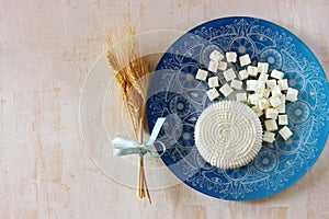 Top view of greek cheese and bulgarian cheese on wooden table over wooden textured background. Symbols of jewish holiday - Shavuot