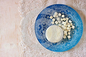 Top view of greek cheese and bulgarian cheese on wooden table over wooden textured background. Symbols of jewish holiday - Shavuot