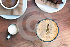 Top view of a greek cold coffee, freddo - frape espresso placed on a wooden table outdoors photo