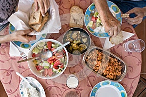 Top view of a Greek lunch meal at summer with omellete, horiatiki salad, feta cheese, grilled vegetables and bread