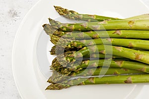 Top view of green asparagus on white plate