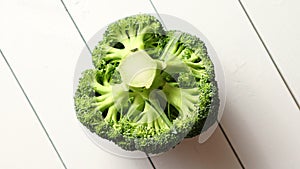Top view of green, fresh, raw broccoli placed on white wooden table