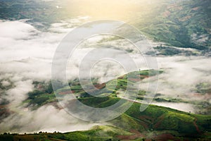Top view of green mountains with clouds in rainy