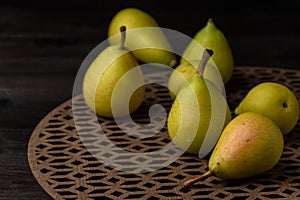 Top view of green pears on wooden table, selective focus, black background