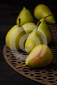 Top view of green pears on wooden table, selective focus, black background