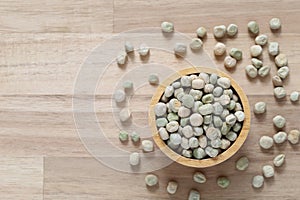 Top view of green peas in a bowl on wooder background, Healthy eating concept