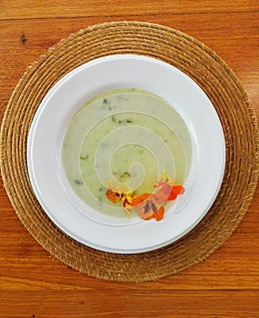 Top view of green soup with comestible flowers photo