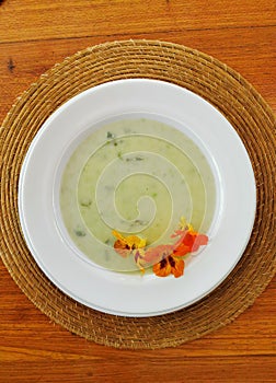 Top view of green soup with comestible flowers photo