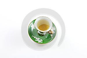 Top view of green and white teacup and saucer with tea