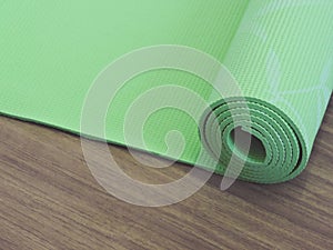 Top view green  yoga mat sport .Rolled up yoga mat isolated on white. Copyspace.